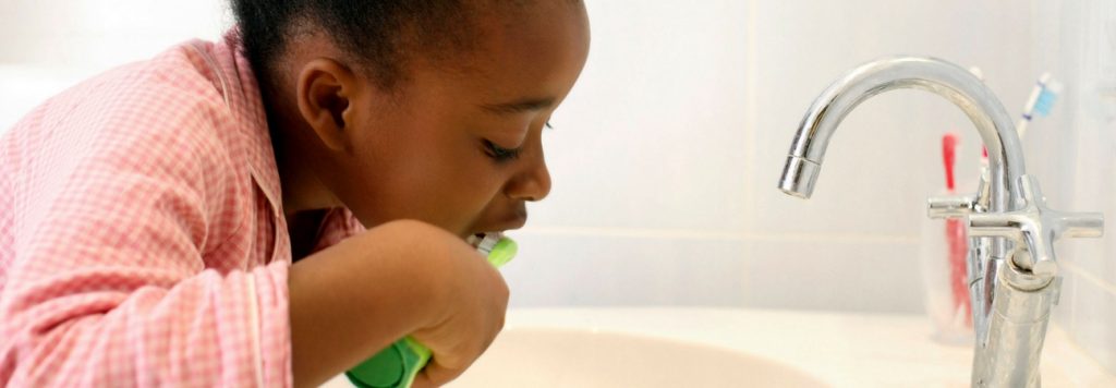 child brushing her teeth to prepare for a dentist appointment near her