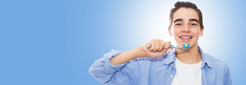 stock photo of teenager brushing teeth for article about pediatric dentist wilson nc